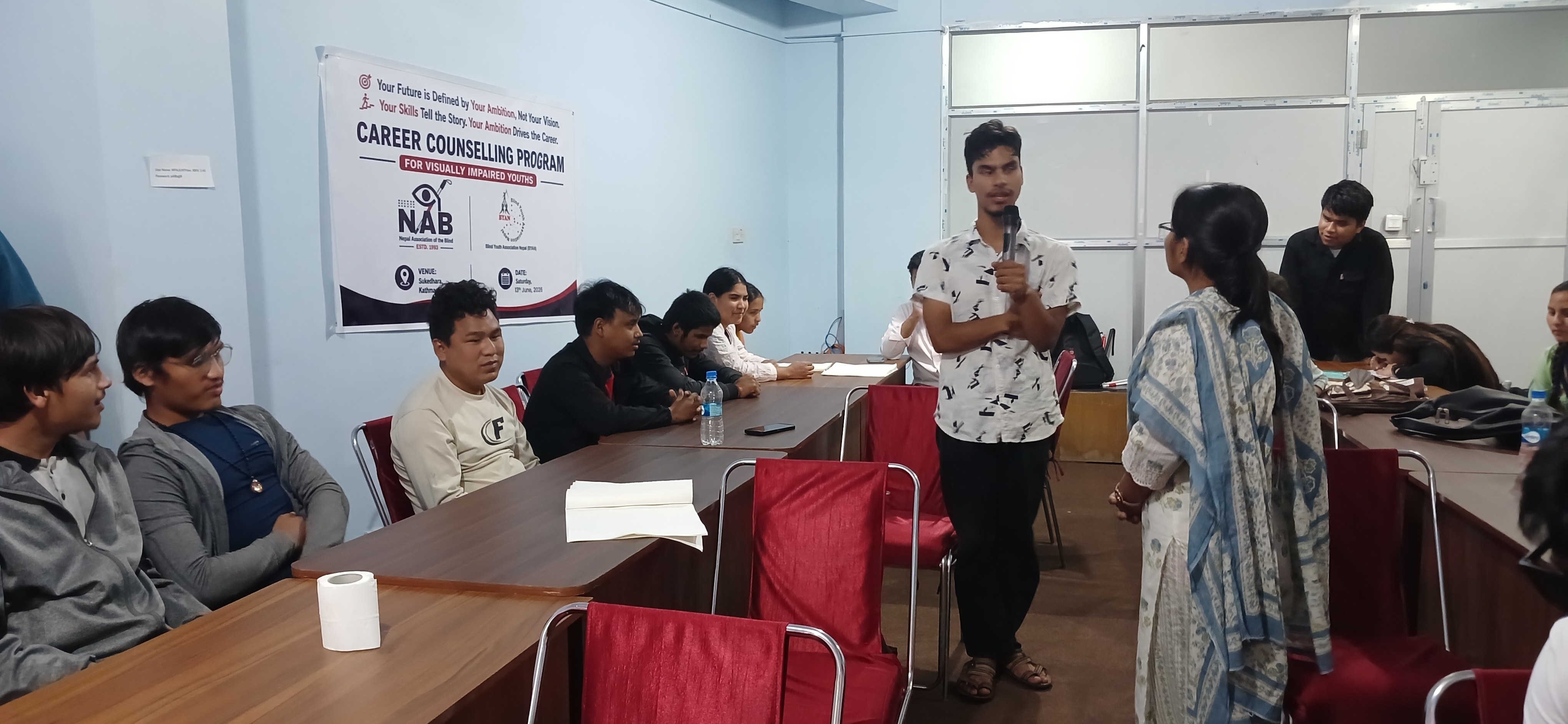 A participant speaking into a microphone at a counselling session